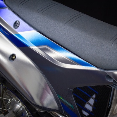 Detalhe da parte traseira de motocicleta cinza e azul com escapamento prateado