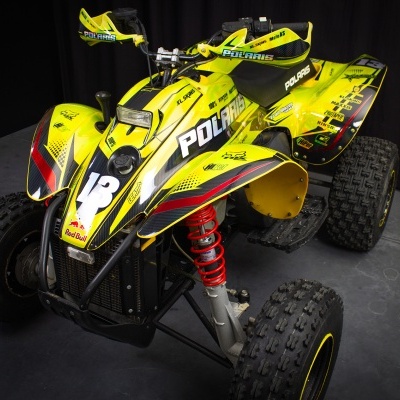 Quad Polaris amarelo e preto com suspensão vermelha e pneus grossos