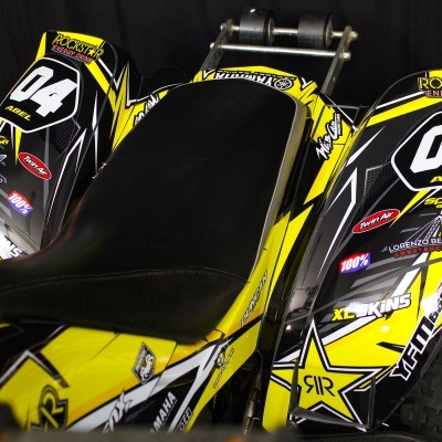 Carrinho de corrida amarelo preto branco com adesivos e pneus de borracha