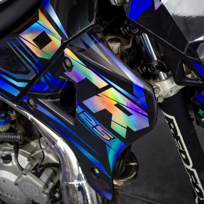 Detalhe de motocicleta desportiva azul com textos VIS e XS KINS