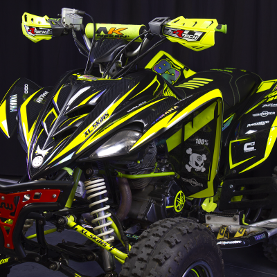 Quad Yamaha Raptor 350 amarelo fluorescente e preto com pneus todo-o-terreno e suspensão visível