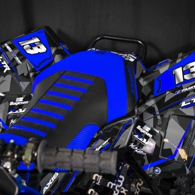 Mota todo-o-terreno azul e preta com número 13 e marcas visíveis