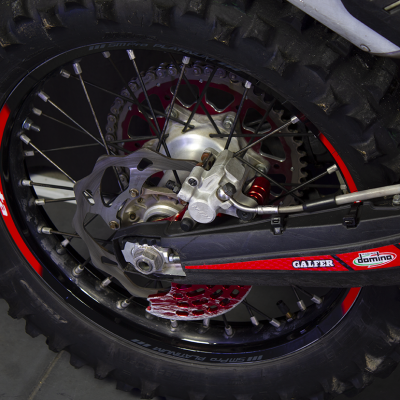 Roda traseira de mota de trilhos com aro preto e detalhes vermelhos