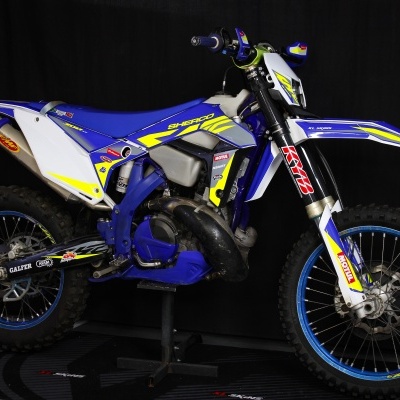 Motocross azul, branco e amarelo com autocolantes e pneus de tacos
