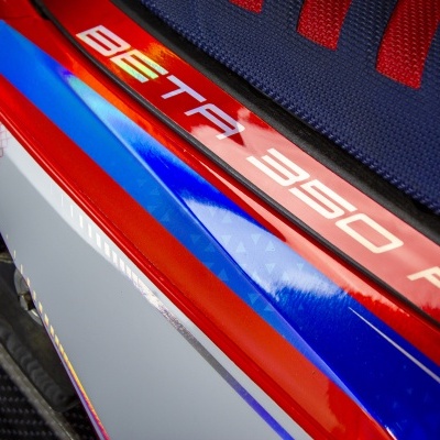 Parte de mota azul, vermelha e branca com texto BETTA 350 RR