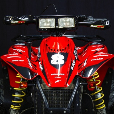 Quad vermelho com detalhes amarelos e autocolantes diversos em fundo preto