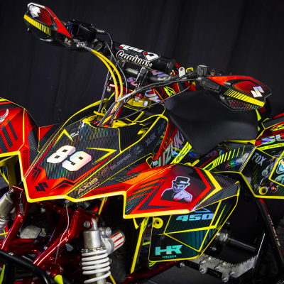Quad Suzuki decorado em vermelho, amarelo e preto com o número 89 e stickers de personagens