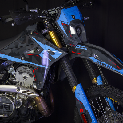 Motociclo Suzuki DR-Z azul e preto com detalhes vermelhos e suspensão dourada