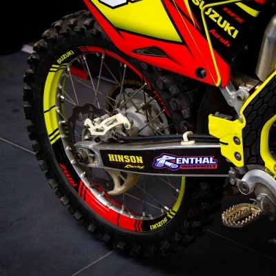 Parte traseira de mota Suzuki de motocross com cores vermelho e amarelo