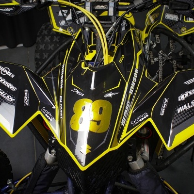 Veículo todo-o-terreno preto com detalhes amarelos e texto