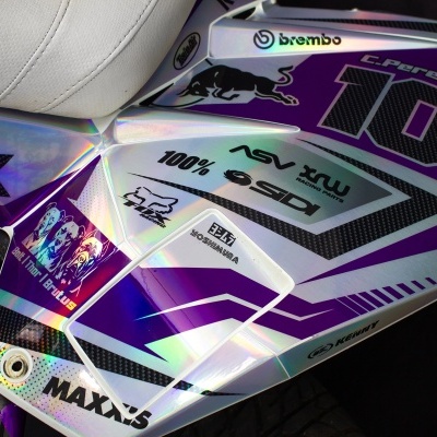 carenagem de motocicleta roxa, branca e preta com número 10 e várias marcas