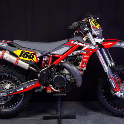 Motocross vermelha, preta e cinzenta com várias marcas e número 166