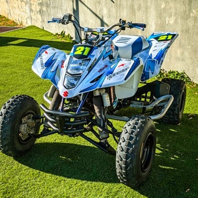 Quad azul e branco com número 21 num chão de relva artificial
