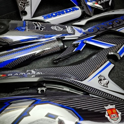 Peças para motocicleta Honda em carbono azul e branco com números e logos.