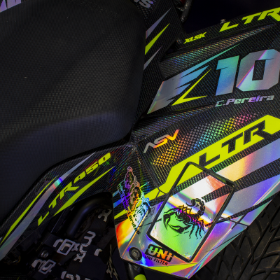 Assento preto e carenagem holográfica de moto com textos e imagem de escorpião