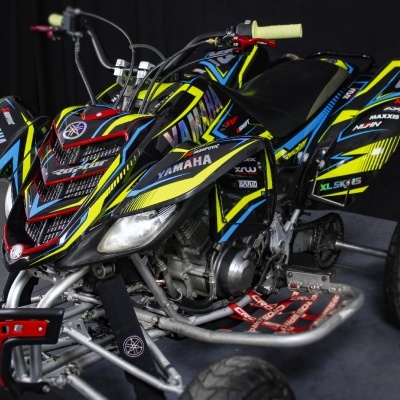 Quadra desportiva Yamaha preta, azul, amarela e vermelha com o número 08 e manípulos amarelos