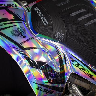 Parte lateral de mota Suzuki com pintura holográfica prateada e assento preto