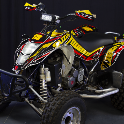 Quad todo-o-terreno amarelo, preto e vermelho com marcas Suzuki, LTZ, XL SKINS e luz frontal