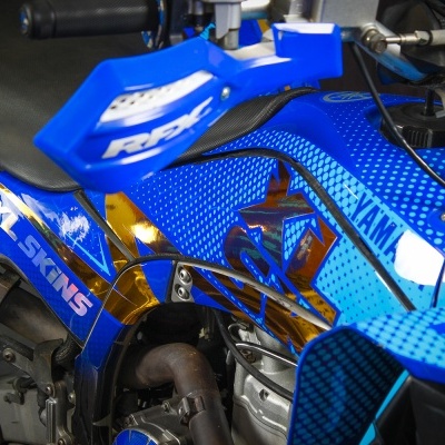 Detalhe de moto azul com autocolantes XL SKINS e YAMAHA na carenagem