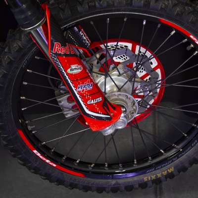 Roda de motocicleta com pneu preto e detalhes vermelhos e logos