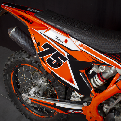 Parte traseira de mota de motocross laranja, preta e branca com nº75 e selim preto