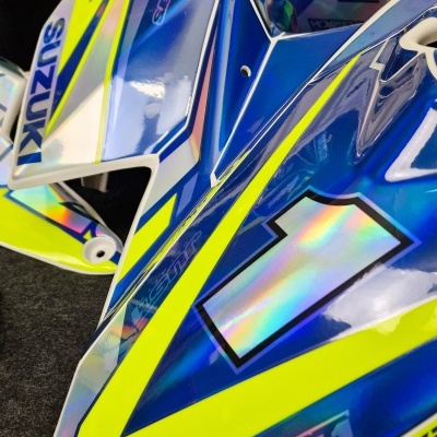 Carenagem azul, amarelo e branco de moto com texto SUZUKI e número holográfico 1.