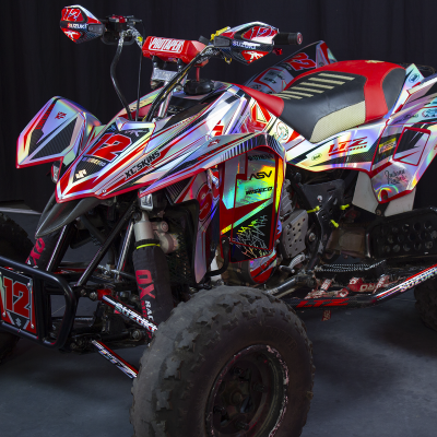 Quad vermelho, branco e preto com número 12, pneus largos e banco preto com detalhes vermelhos