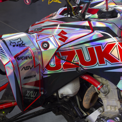 Motociclo Suzuki com grafismo holográfico e logótipos várias marcas