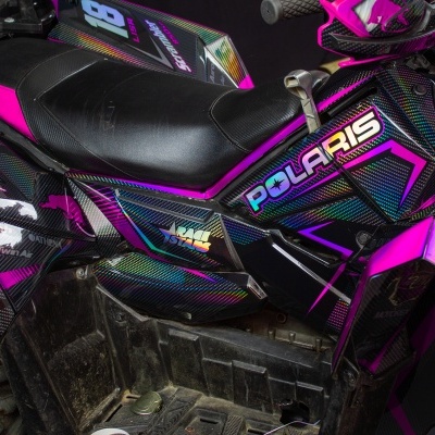 Veículo todo-o-terreno Polaris preto e rosa com padrão carbono e assento em couro preto