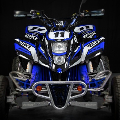Quad Suzuki Z400 preto, azul e branco com o número 11, em fundo preto