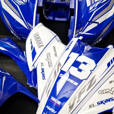 Carenagens azuis e brancas para moto Yamaha com números 13 e várias marcas