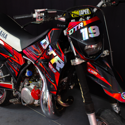 Motociclo Yamaha preto, vermelho e branco com logótipos DTR 119 e YAMAHA