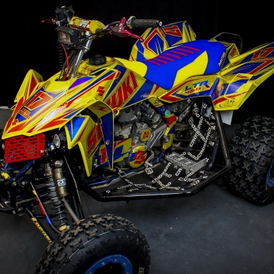 Quadriciclo amarelo, azul e vermelho em fundo negro