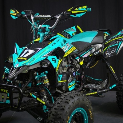Quad Suzuki turquesa e preto com número 17 e detalhes amarelos, pneus grossos e textos LTR, SUZUKI, XL SKINZ e EIKA