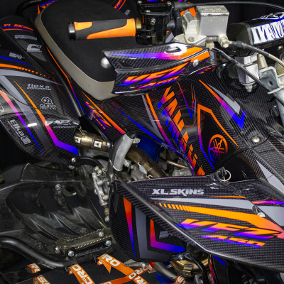 Quadro desportivo em fibra de carbono com detalhes laranja, roxo e azul e textos XL-SKINS e Yamaha
