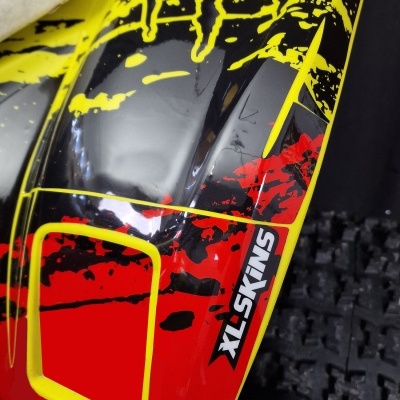 equipamento desportivo vermelho, amarelo e preto com texto XL-SKINS