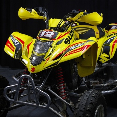 Quad amarelo com marca Suzuki e número 12 em fundo preto