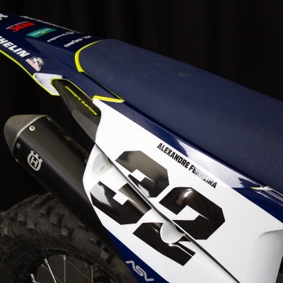 Assento azul de mota off-road com número 32 e marcas Michelin e Husqvarna