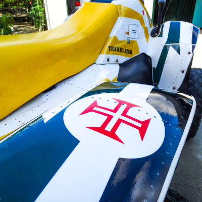 Quadriciclo com banco amarelo e pintura colorida com texto TRAILBLAZER e símbolo vermelho