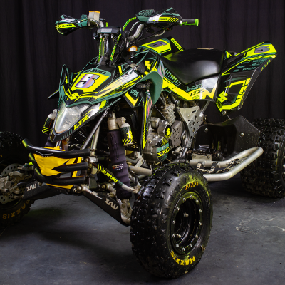 Quad Suzuki LTZ verde, amarelo e preto com número 5 em fundo cinzento e preto