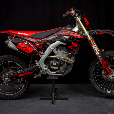 Motocross Honda preta e vermelha número 99 com pneus de cravos