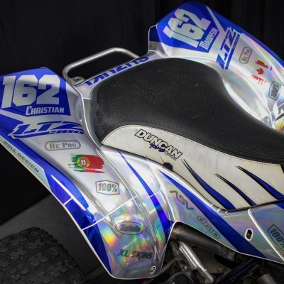 Quadriciclo azul, branco e prateado com banco preto e autocolantes diversas