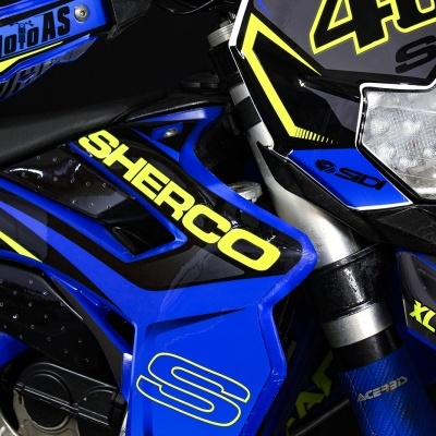 Motocicleta Sherco azul preto e amarelo com farol e números 48