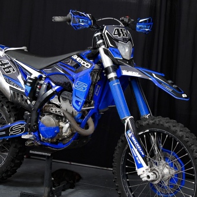 Motociclo de competição azul e preto com número 46 e marcas Sherco e Michelin