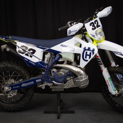 Motocross branca e azul Husqvarna número 32 em fundo preto