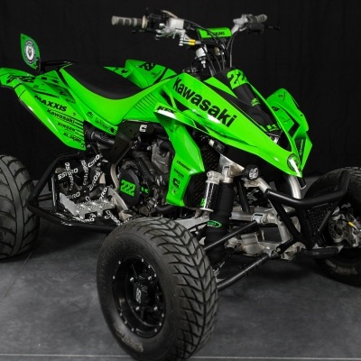 Quad Kawasaki verde e preto com números 222 e vários autocolantes em fundo escuro