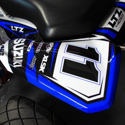 Parte traseira de motocicleta Suzuki LTZ 400 azul e branco, com número 11 no capot.