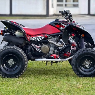 Quadriciclo Honda ATV vermelho e preto em relva