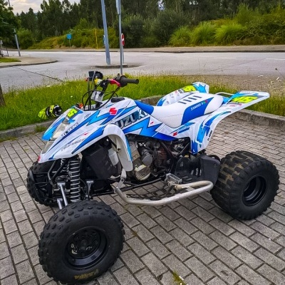 Quad Suzuki azul e branco com pneus largos e detalhes amarelos
