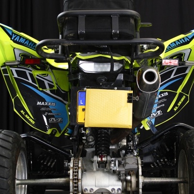 Quadriciclo Yamaha visto de trás com decoração preta, amarela e azul e pneus largos